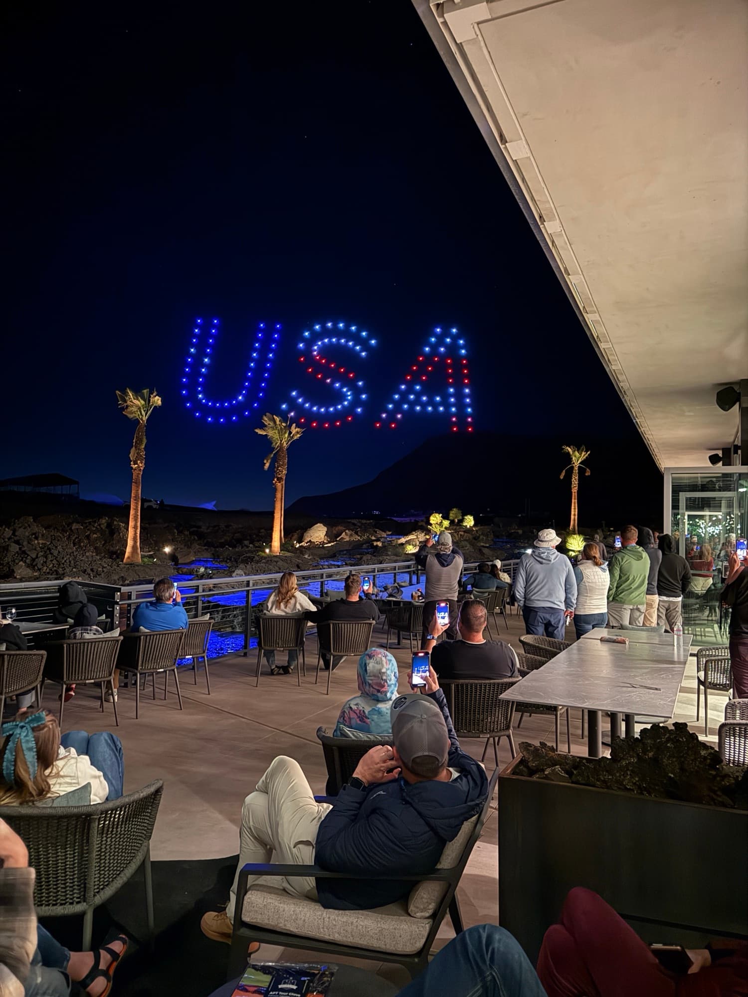 USA spelled in red, white and blue drones above a resort terrace on the Fourth of July