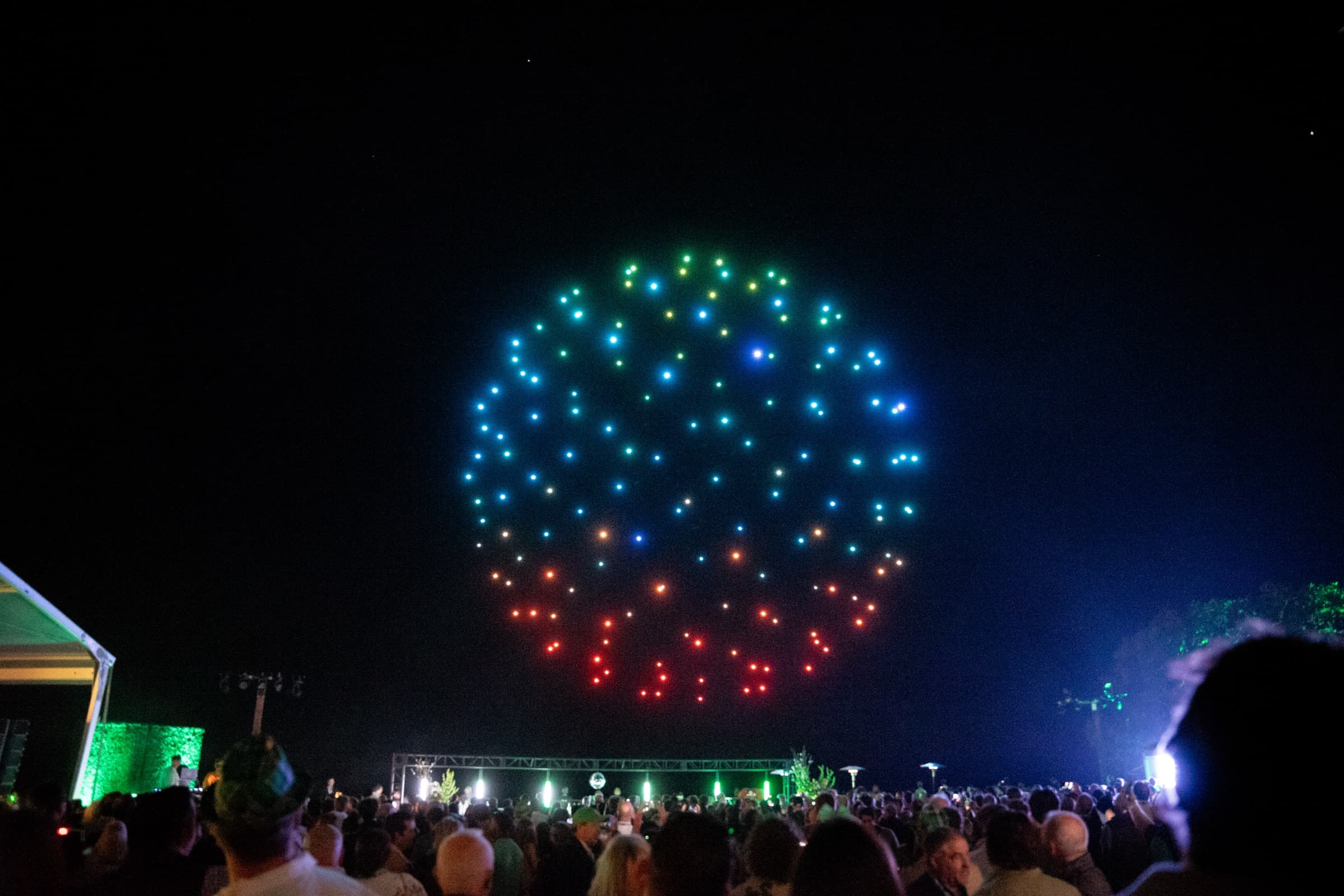 Rainbow sphere formation above a festival stage